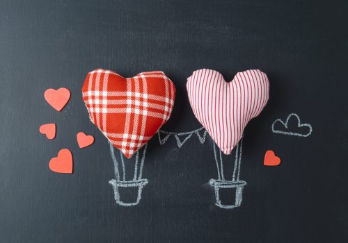 Valentines day concept with heart shapes as air balloons over chalkboard background. Top view from above